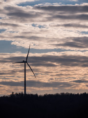 Fototapeta na wymiar Windturbine renewables forest silhouette clouds