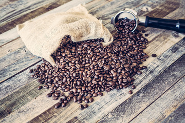 Roasted coffee beans in a bag on wooden background