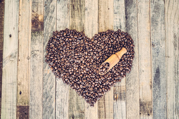 Coffee beans in a shape of heart on wooden background