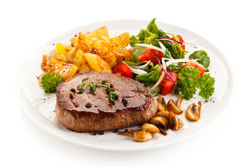 Grilled beef steak with baked potatoes and vegetables