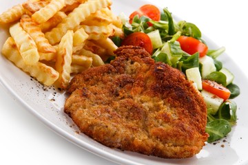 Fried pork chop, French fries and vegetables 