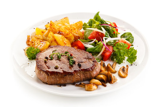 Grilled beef steak with baked potatoes and vegetables