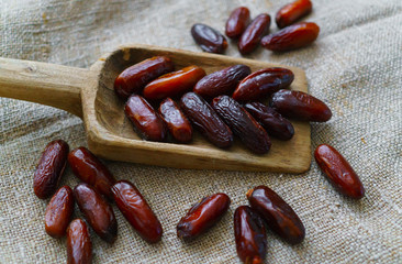 Fresh dates on a wooden old tray lying on the table.