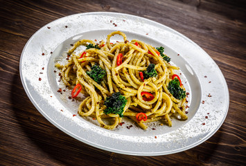 Pasta with collard on wooden table