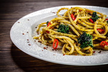 Pasta with collard on wooden table