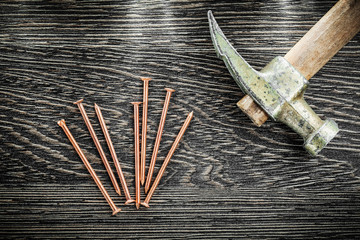 Claw hammer brass nails on wooden board top view