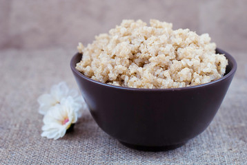 Boiled cereals quinoa in a deep plate on a linen tablecloth
