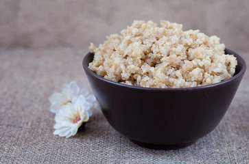 Boiled cereals quinoa in a deep plate on a linen tablecloth