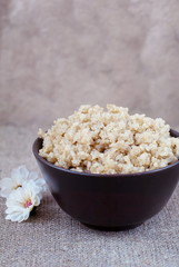 Boiled cereals quinoa in a deep plate on a linen tablecloth