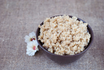 Boiled cereals quinoa in a deep plate on a linen tablecloth