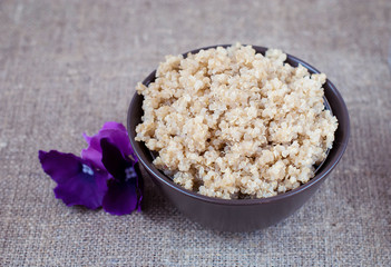 Boiled cereals quinoa in a deep plate on a linen tablecloth