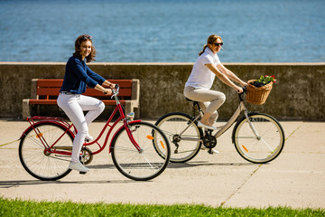 Naklejka premium Women biking on pier