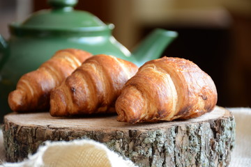 freshly baked croissants on wooden cutting board. Breakfast with croissants. 