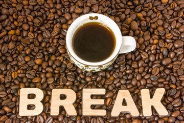 Coffee break photo. Cup with brewed coffee is on table, which filled with roasted coffee beans, next to word break. Idea to designate break for conferences, seminars, trainings and educational events