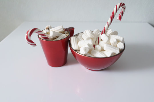 Christmas background, greeting card with a Cup of coffee or chocolate with marshmallows, lollipops and a red plate