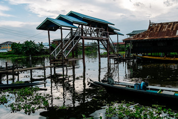 Ancient houses and their reflection in the water on the Inle Lake, Myanmar