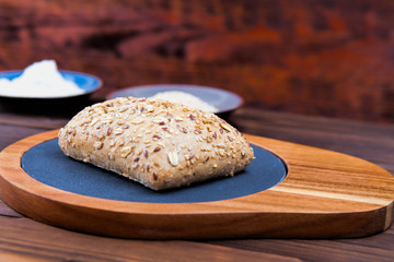 Fresh bread on a cutting board. Wooden background