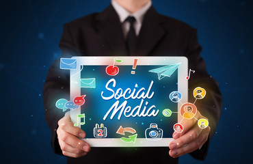 Businessman holding tablet with social media graphics