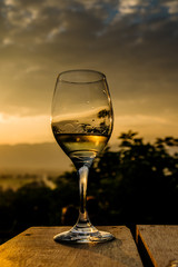 one glass of wine in the background landscape with dramatic sky during sunset. The mountains in Myanmar, Inle lake