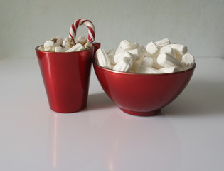 Christmas background, greeting card with a Cup of coffee or chocolate with marshmallows, lollipops and a red plate