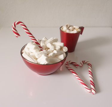 Christmas background, greeting card with a Cup of coffee or chocolate with marshmallows, lollipops and a red plate