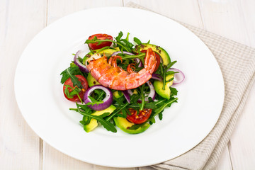 Salad with shrimps on white wooden table