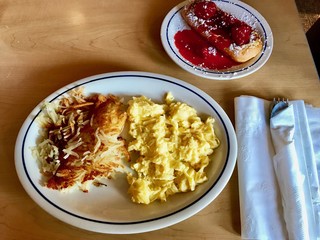 American Breakfast: Hashbrowns, Scrambled Eggs and Sweet Pastry at a Family Restaurant