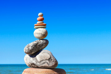 Gray and red zen stones on the background of the sea. Concept of harmony, balance and meditation.