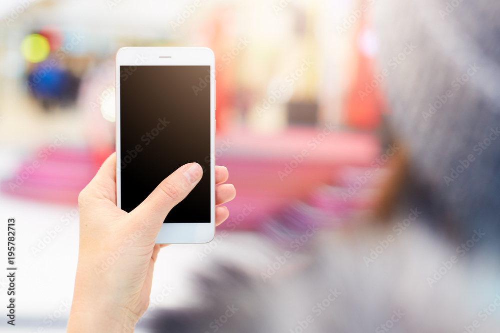 Wall mural shot of unrecognizable woman holds modern cell phone with blank black screen watches video or views 