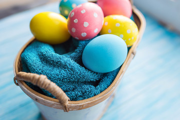 Easter eggs in the basket on rustic background
