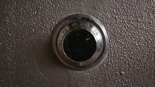 Hand entering frame and dialing a combination code
