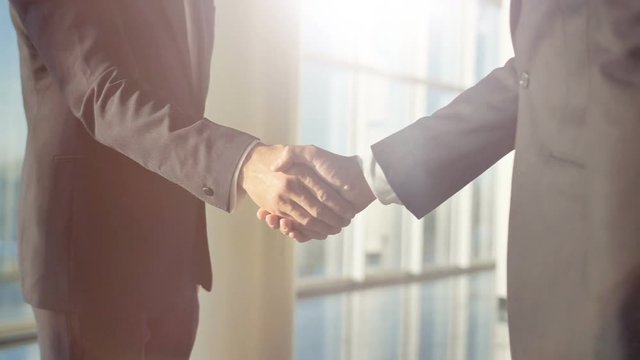 The businessmen handshake in the office. slow motion