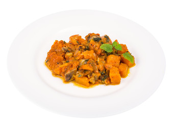 White plate with pumpkin in curry sauce