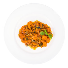 White plate with pumpkin in curry sauce