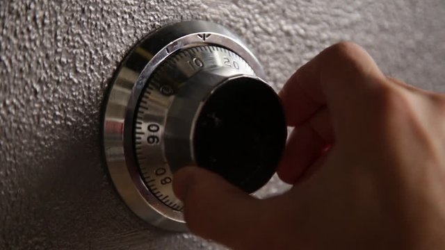 Extreme close up - hand opening and closing a safe with combination lock