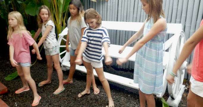 A young girl teaches her friends how to do a dance routine