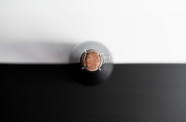a bottle of champagne with a closed stopper view from the top on a black - white background concept