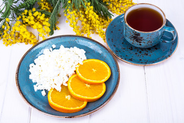 Concept of healthy dietary nutrition. Fresh raw cottage cheese with fruit, herbal tea