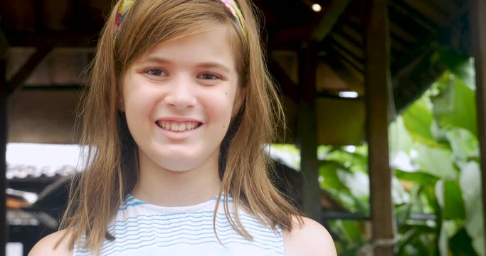 Portrait of a cute 11 - 12 year old girl with a headband smiling