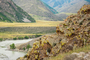 Red-green rocks on the shore of Katun river. Altai mountains