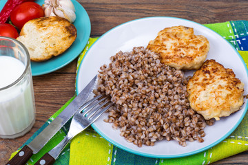 Buckwheat porridge with cutlets on white plate
