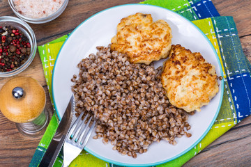 Buckwheat porridge with cutlets on white plate