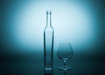 Empty bottle and a skateglass on a blue graded background