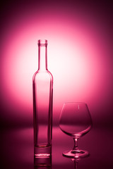 Empty bottle and a skateglass on a red graded background