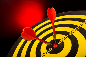 Dart board targeting the center on a  red background. abstract of success - close-up.