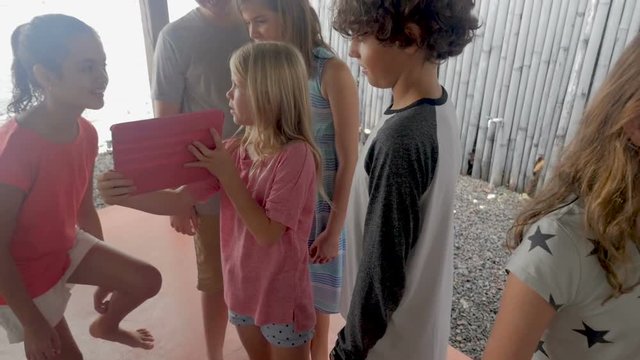 Young girl looking at a digital tablet with her friends