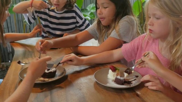 Happy bunch of young girls sharing their desserts together in slow motion