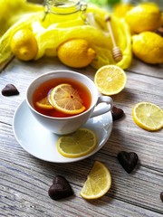 tea with lemons in a rustic style on white wooden background 