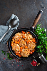 Veal meatballs stewed in frying pan with carrot in vegetable sauce. Delicious meat dish