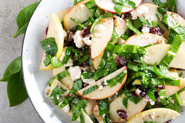 Healthy fruit and berry salad with fresh apples, cranberries, walnuts, italian ricotta cheese and spinach leaves. Delicious and nutritious diet dish for breakfast